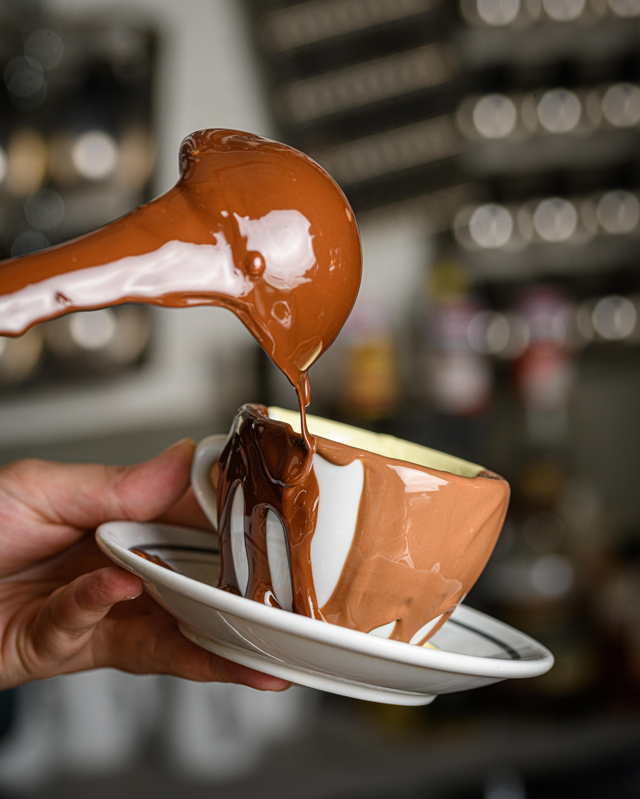 Hot chocolate, waffles, patisserie and strawberries served together on a table